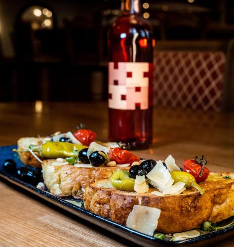 a piece of toast with vegetables on a plate with a bottle at Hotel-Restaurant Kreuzberghof Tagungs- und Veranstaltungshotel in Tiefenbach