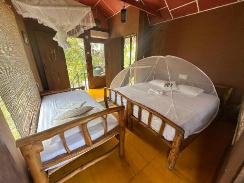 a bedroom with two beds in a room at Yala Eco Tree House in Tissamaharama