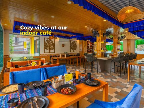 un restaurante con mesas y sillas azules y una barra en The Hosteller Mcleodganj, Bhagsu, en McLeod Ganj