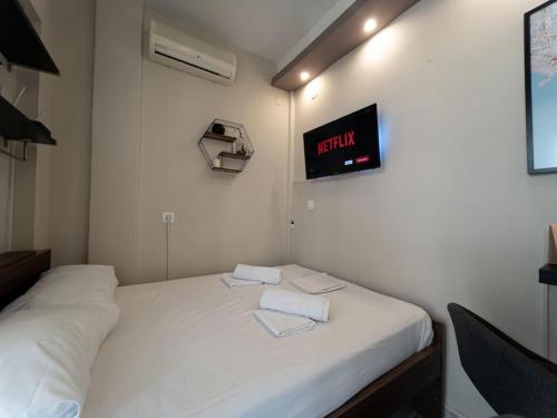a room with a white bed with a clock on the wall at BedCity Apartment with Free Parking in the City Center in Thessaloniki