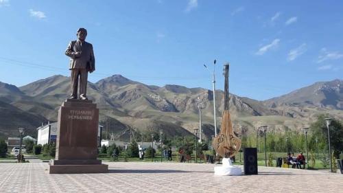 a statue of a man standing next to a baseball glove at Mikasa Guest House in Naryn