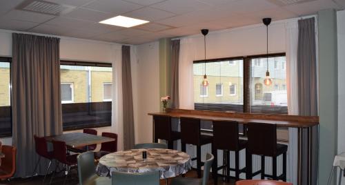 un comedor con bar, mesa y sillas en Hostel Snoozemore, en Gotemburgo