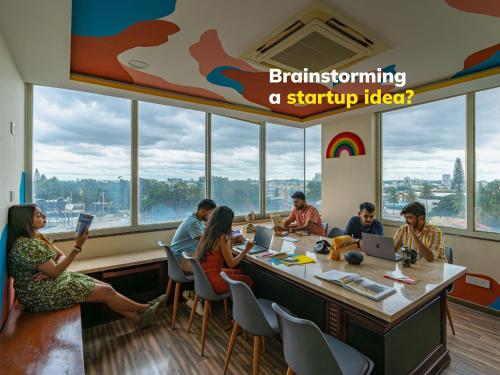 a group of people sitting around a table in a restaurant at The Hosteller Bangalore, Brigade Road in Bangalore