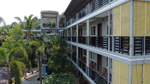 an apartment building with balconies and palm trees at Roomy Guesthouse in Koh Rong Island