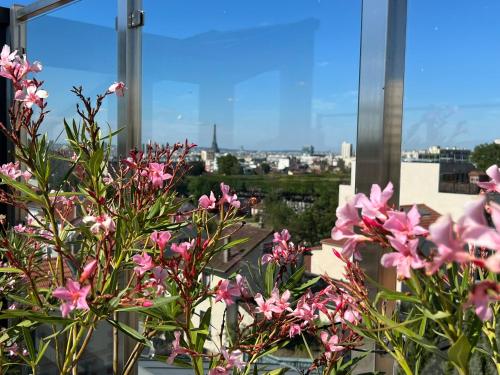 un ramo de flores rosas delante de una ventana en Grand Appartement de standing Rooftop Jacuzzi, en Malakoff