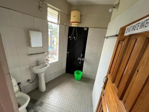a bathroom with a sink and a toilet and a window at Sweet Rooms near Police Bazar in Shillong