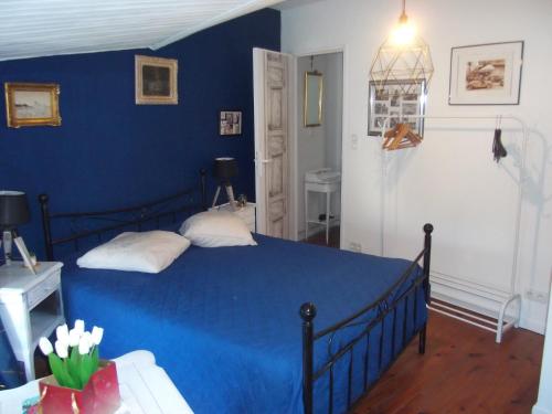 a blue bedroom with a bed and a blue wall at les mésanges in La Grève-sur-Mignon