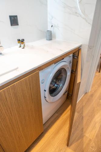 a washing machine in a kitchen under a counter at Volos Inn Hotel in Volos