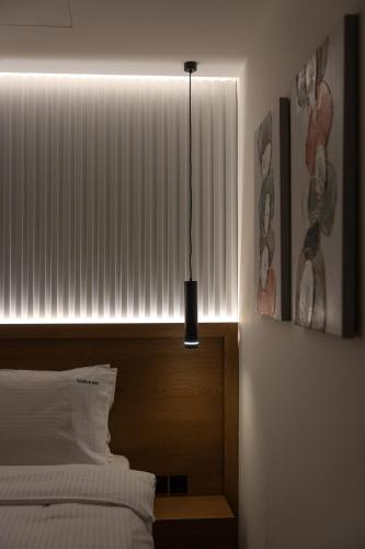 a bedroom with a bed and a window with a light at Volos Inn Hotel in Volos