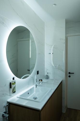 a white bathroom with a sink and a mirror at Volos Inn Hotel in Volos