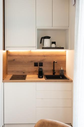a kitchen with white cabinets and a sink at Volos Inn Hotel in Volos