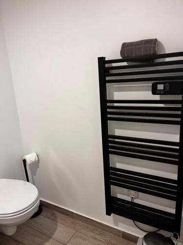 La salle de bains est pourvue de toilettes et d'une commode noire et blanche. dans l'établissement Studio proche gare et Versailles 4 min à pied train vers Paris, à Marly-le-Roi