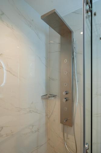 a bathroom with a shower with a glass door at Volos Inn Hotel in Volos
