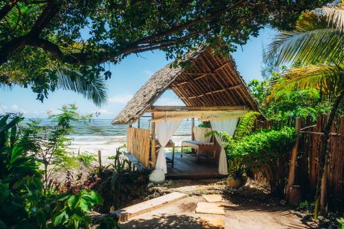 een hut op het strand met de oceaan op de achtergrond bij Marafiki Bungalows in Kiwengwa