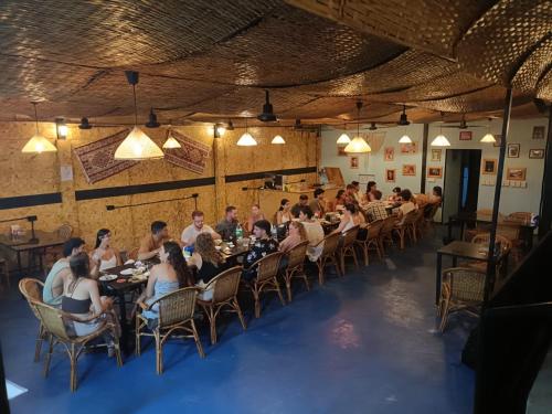 un grupo de personas sentadas en mesas en un restaurante en Roomy Guesthouse, en Koh Rong