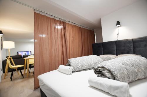 a bedroom with two white beds and a dining room at The Maze Apartment in Ljubljana