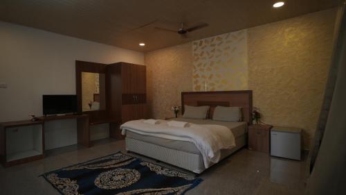 a bedroom with a large bed and a television at Patnem Palm Garden in Palolem