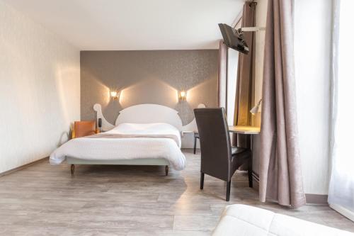 a bedroom with two beds and a desk at Logis SPA Hotel Restaurant De La Poste in Tence