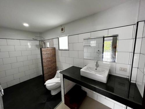 La salle de bains est pourvue d'un lavabo et de toilettes. dans l'établissement The Wok Tum Manor!, à Ko Pha Ngan