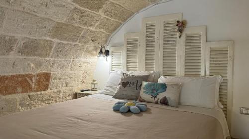 1 dormitorio con 1 cama con pared de piedra en B&B Casa Fiore, en Polignano a Mare