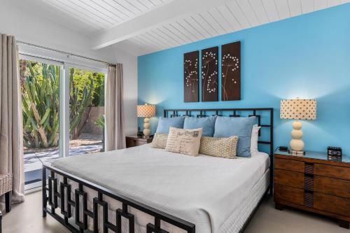 um quarto com uma cama grande e paredes azuis em R & R Rendezvous em Palm Springs