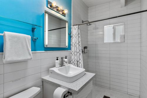 uma casa de banho branca com um lavatório e um espelho em R & R Rendezvous em Palm Springs