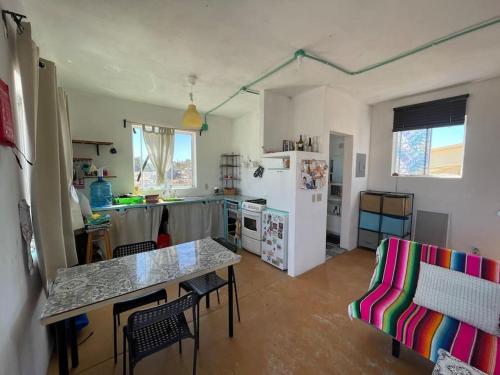 a kitchen with a refrigerator and a table and chairs at Casita de renta frente la playa in San Juanico