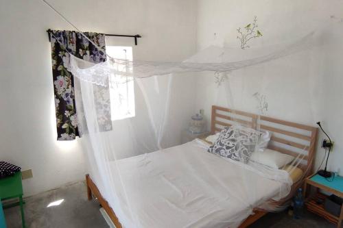 a bedroom with a bed with a mosquito net at Casita de renta frente la playa in San Juanico