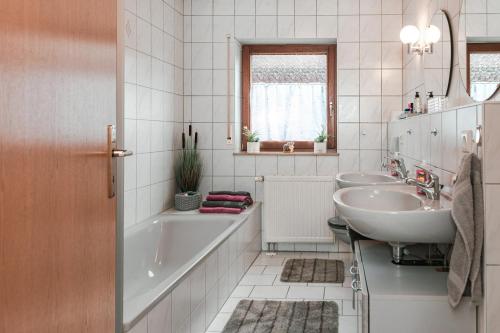 a bathroom with a tub and a sink and a tub and a toilet at Ferienwohnung Speidel Rottenburg am Neckar in Rottenburg