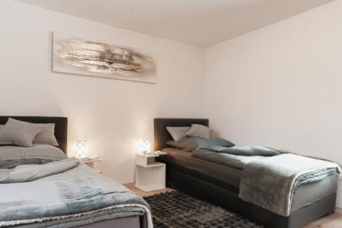 a bedroom with two beds and a painting on the wall at Ferienwohnung Speidel Rottenburg am Neckar in Rottenburg