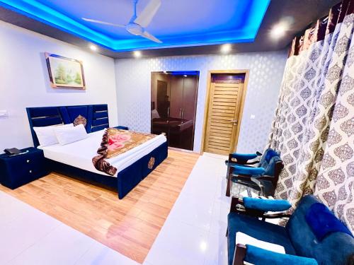 a bedroom with a bed and a blue ceiling at Imperial lodges in Islamabad