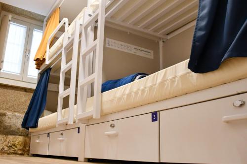 Etagenbett in einem Zimmer mit Schubladen in der Unterkunft Albergue SP 55 by Bossh! Hotels in Santiago de Compostela