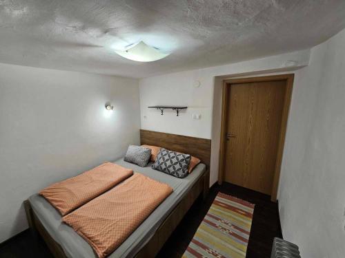 a small bedroom with a bed and a door at Apartment Slavija in Škofja Loka