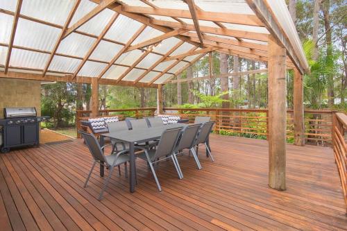 a wooden deck with a table and chairs and a grill at Riverslea Retreat in Margaret River Town