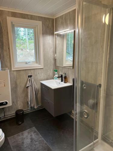 a bathroom with a sink and a shower at Water front scandinavian Forest View with no neighbors in Östmarken