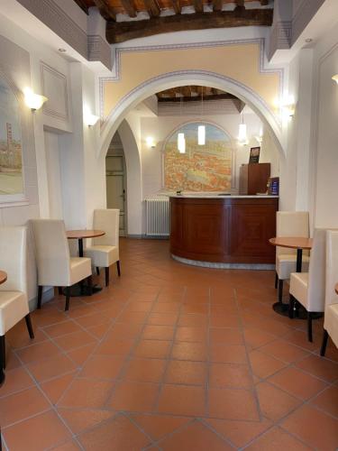una sala con mesas y sillas y una sala de audiencias en San Pietro Tuscany Suites, en Lucca