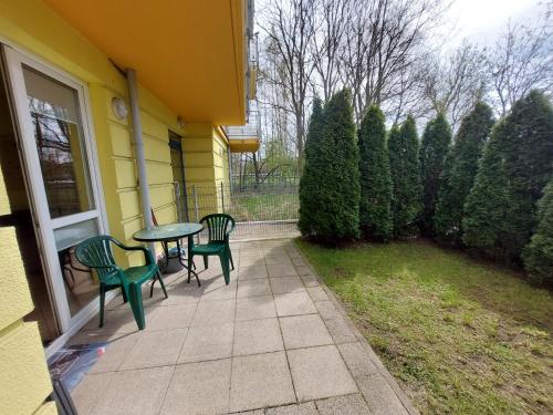 a patio with two chairs and a table on a house at Apartament z Ogródkiem in Kołobrzeg