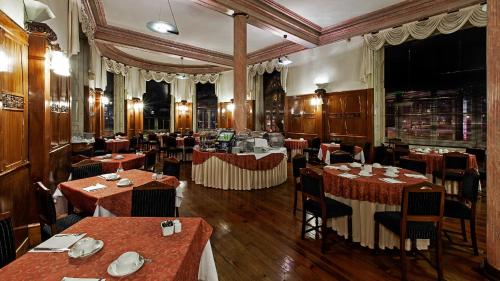 a restaurant with tables and chairs in a room at Hotel Astoria in Coimbra