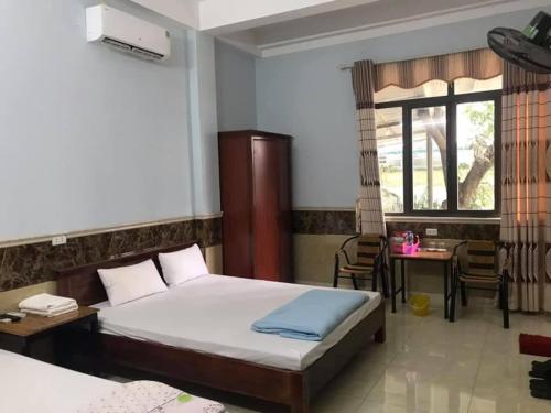 um quarto com uma cama, uma secretária e uma janela em Nhà Nghỉ Việt Hùng em Mai Châu