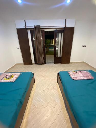 2 camas en una habitación con puertas en شاليه للايجار اليومي بالريف الاوروبي en Qaryat ash Shamālī