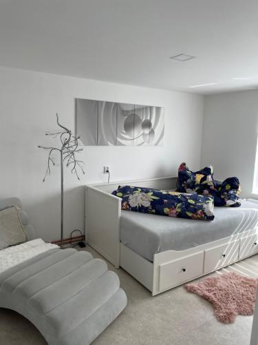 1 dormitorio blanco con 1 cama y 1 silla en U Vlcaku, en Vřesovice