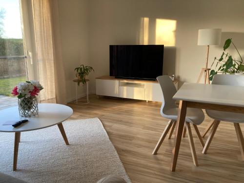 a living room with a television and a table and chairs at moderne 2-Zimmer-Wohnung mit Terrasse in Tönnhausen