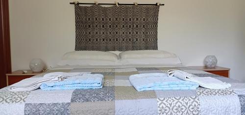 a bed with two towels and two pillows on it at Agriturismo Muristene in Dorgali
