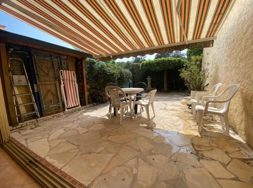 d'une terrasse avec une table et des chaises sous un plafond en bois. dans l'établissement Appartement T2 au bord de mer avec parking, terrasse et piscine, à Sainte-Maxime