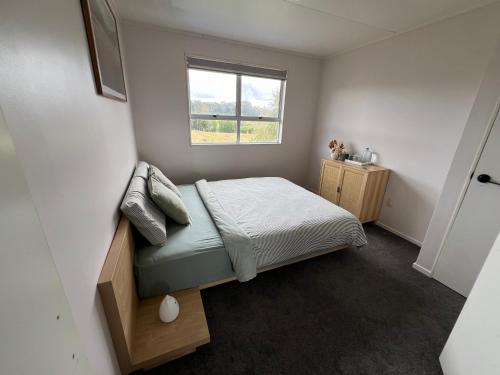 a small bedroom with a bed and a window at Private Room in Kawakawa