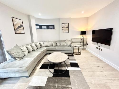 sala de estar con sofá y TV de pantalla plana en Holocene Luxury Apartments London en The Hyde