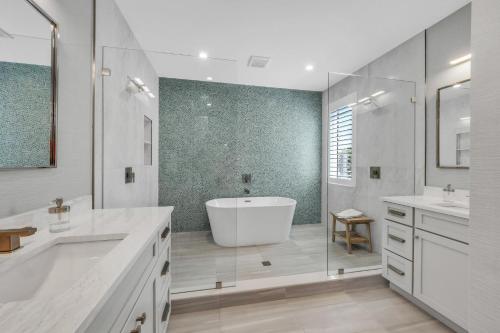 un bagno bianco con vasca e lavandino di Villa Rayo Del Sol a Bradenton Beach