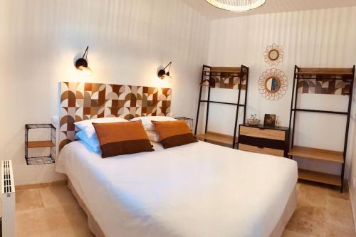 une chambre avec un grand lit blanc dans une pièce dans l'établissement Maison bretonne 400m des plages Vélos gratuits, à Plouguerneau