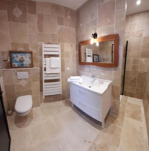 une salle de bain avec un lavabo et des toilettes dans l'établissement Maison bretonne 400m des plages Vélos gratuits, à Plouguerneau