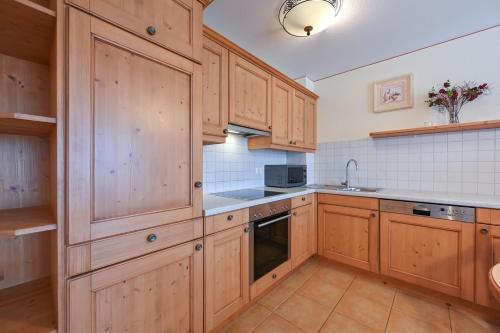 a kitchen with wooden cabinets and a sink at Residenz Sonnenhang II in Füssen